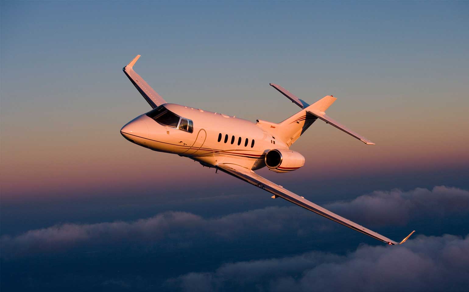 Hawker 850XP private jet charter flying during sunset